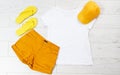 Casual white t-shirt, yellow cap yellow flip flops shirts top view Royalty Free Stock Photo