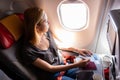 Casual woman flying on commercial passengers airplane, filling in immigration form.