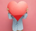 Casual woman hiding her face behind a big red heart Royalty Free Stock Photo