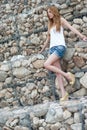 Casual woman leaning on a huge rock wall