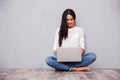 Casual woman sitting on the floor with laptop