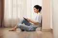 woman sitting on the floor and working on laptop at home Royalty Free Stock Photo