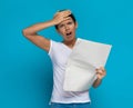 Casual woman slapping her head after reading the newspaper Royalty Free Stock Photo