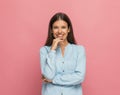 Casual woman touching her chin, smiling and sending positive vibes