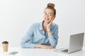 Casual working day in office. Portrait of positive good-looking businesswoman in glasses, sitting near laptop smartphone Royalty Free Stock Photo