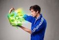 Casual boy holding laptop with recycle and environmental symbols Royalty Free Stock Photo