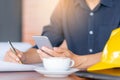 Casual young business man hand using mobile smart phone with silver pen and coffee blurred background Royalty Free Stock Photo