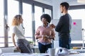 Casual young business people using his mobile phone and drinking coffee while taking a break in the new office Royalty Free Stock Photo