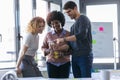 Casual young business people using his mobile phone and drinking coffee while taking a break in the new office Royalty Free Stock Photo