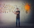 Casual young man, confused face expression, holding hands outstretched as receiving a lot of ideas gathering and create a Royalty Free Stock Photo