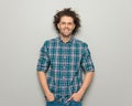 casual young man with glasses wearing plaid shirt and holding hands in pockets Royalty Free Stock Photo