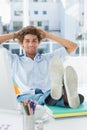 Casual young man with legs on desk in bright office Royalty Free Stock Photo