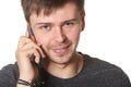 Casual young man with light beard, listening on mobile phone, is