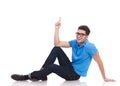 Casual young man lying on the floor is pointing up Royalty Free Stock Photo