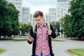 Casual young man in plaid shirt with backpack walking in the city Royalty Free Stock Photo