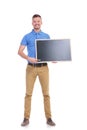 Casual young man points with chalk at blackboard Royalty Free Stock Photo