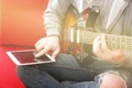 Casually dressed young man with guitar playing songs in the room at home. Online guitar lessons concept. Male guitarist practicing Royalty Free Stock Photo