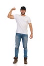 Casual Young Man Is Standing, Flexing Biceps And Smiling Royalty Free Stock Photo