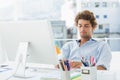 Casual young man using computer in bright office Royalty Free Stock Photo