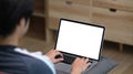 Casual young man using computer laptop while sitting on couch in living room. Royalty Free Stock Photo