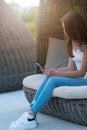 Casual young woman in jeans seated in a chair Royalty Free Stock Photo