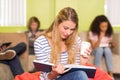 Casual young woman reading book in office Royalty Free Stock Photo