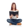 Casual young woman sitting on the floor reading a book Royalty Free Stock Photo