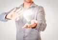 Casually dressed businessman with floating lightbulb shining bright above his hand. Business idea concept image with copy space