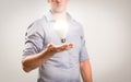 Casually dressed businessman with floating lightbulb shining bright above his hand. Business idea concept image with copy space