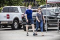 Casually dressed couple walk passed cars in parking lot wearing masks during pandemic