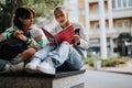 Casually dressed high school girls study outdoors, writing homework and preparing for an exam. Royalty Free Stock Photo