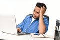 Startup business man holding his head looking stressed while working on a laptop Royalty Free Stock Photo