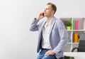 Casually dressed young businessman talking on phone in office Royalty Free Stock Photo