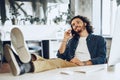 Casually dressed young businessman using mobile phone in office Royalty Free Stock Photo