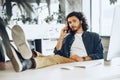 Casually dressed young businessman using mobile phone in office Royalty Free Stock Photo