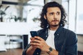 Casually dressed young businessman using mobile phone in office Royalty Free Stock Photo