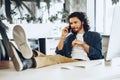 Casually dressed young businessman using mobile phone in office Royalty Free Stock Photo