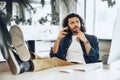 Casually dressed young businessman using mobile phone in office Royalty Free Stock Photo