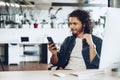 Casually dressed young businessman using mobile phone in office Royalty Free Stock Photo