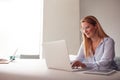 Casually Dressed Young Businesswoman Working On Laptop In Modern Meeting Room