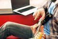 Casually dressed young man with guitar playing songs in the room at home. Online guitar lessons concept. Male guitarist practicing Royalty Free Stock Photo