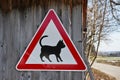 Cat caution sign in rural area on wall of barn