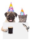 Cat and dog in birthday hats holding fish and beer peeking from behind empty board. isolated on white background Royalty Free Stock Photo