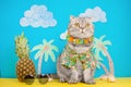 A cat on holiday in a Hawaiian shirt with pineapples. On the beach with malma. A concept of rest, relaxation, vacation Royalty Free Stock Photo