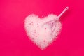 Cat litter, heart shaped bright pink background with a spatula for cleaning poop. Concept for labels, packaging advertising of the