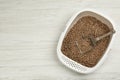 Cat litter tray with filler and scoop on white wooden floor, top view. Space for text Royalty Free Stock Photo