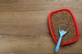 Cat litter tray with filler and scoop on wooden floor, top view. Space for text Royalty Free Stock Photo