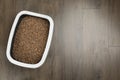 Cat litter tray with filler on wooden floor, top view. Space for text Royalty Free Stock Photo