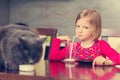 Cat and little girl drinking milk. Royalty Free Stock Photo