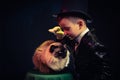 Cat and Magician kid illusionist boy in hat. mystery magical black background